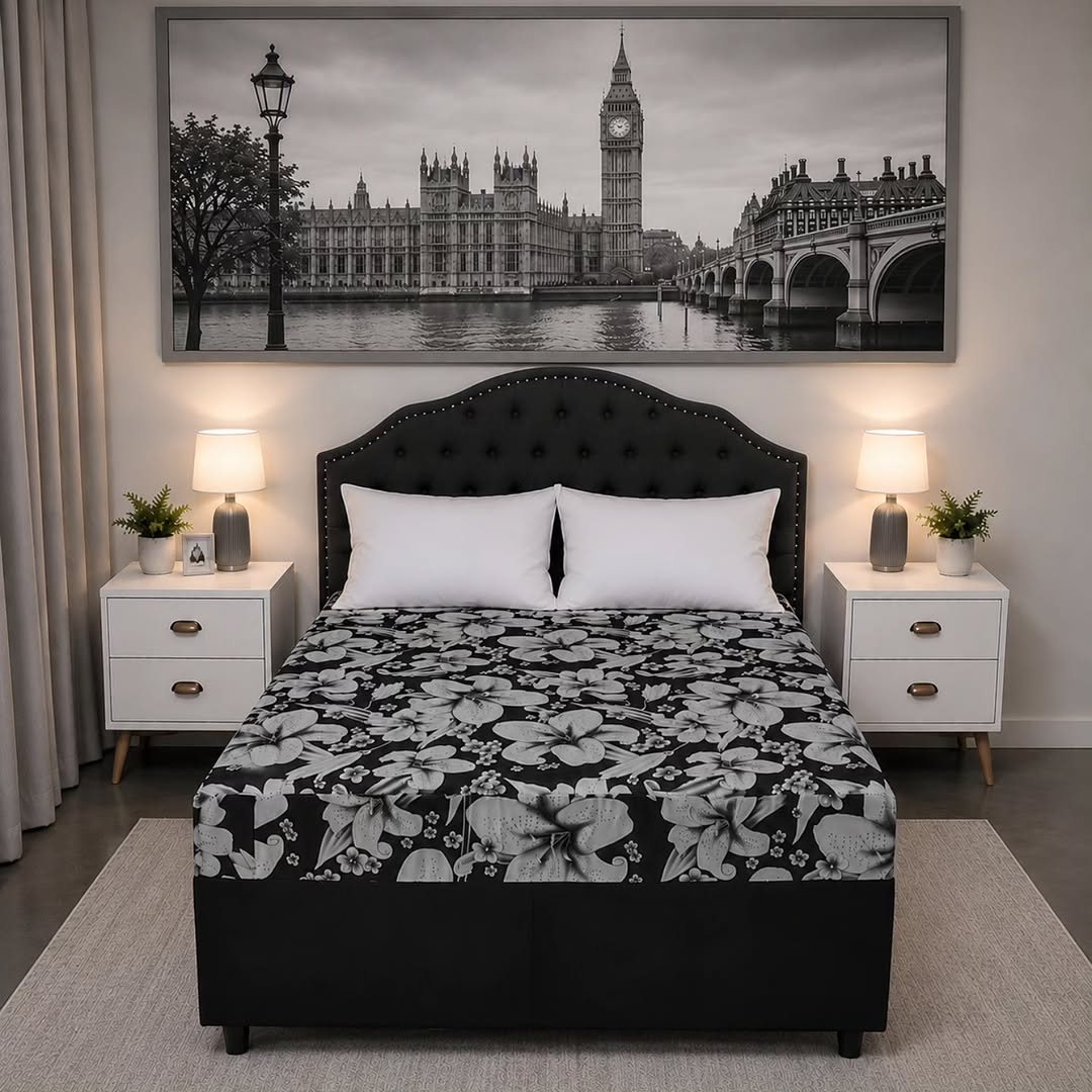 Cama com estampa floral e luminárias de cabeceira acesas